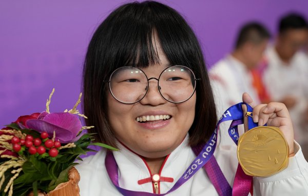 Zuo Wenjing smiling, holding up her Asian Games gold medal.